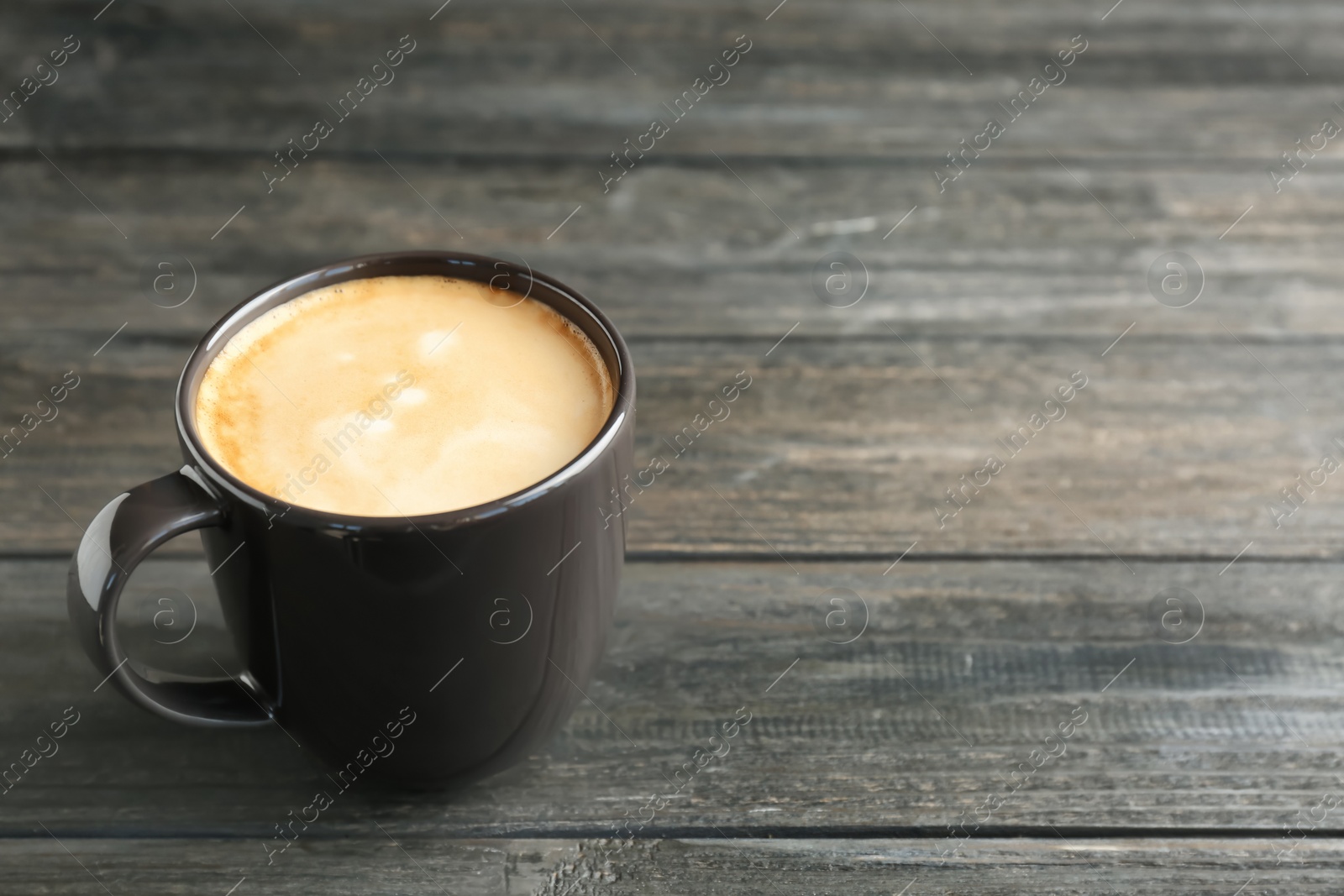 Photo of Cup of aromatic hot coffee on wooden background