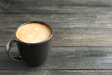 Cup of aromatic hot coffee on wooden background