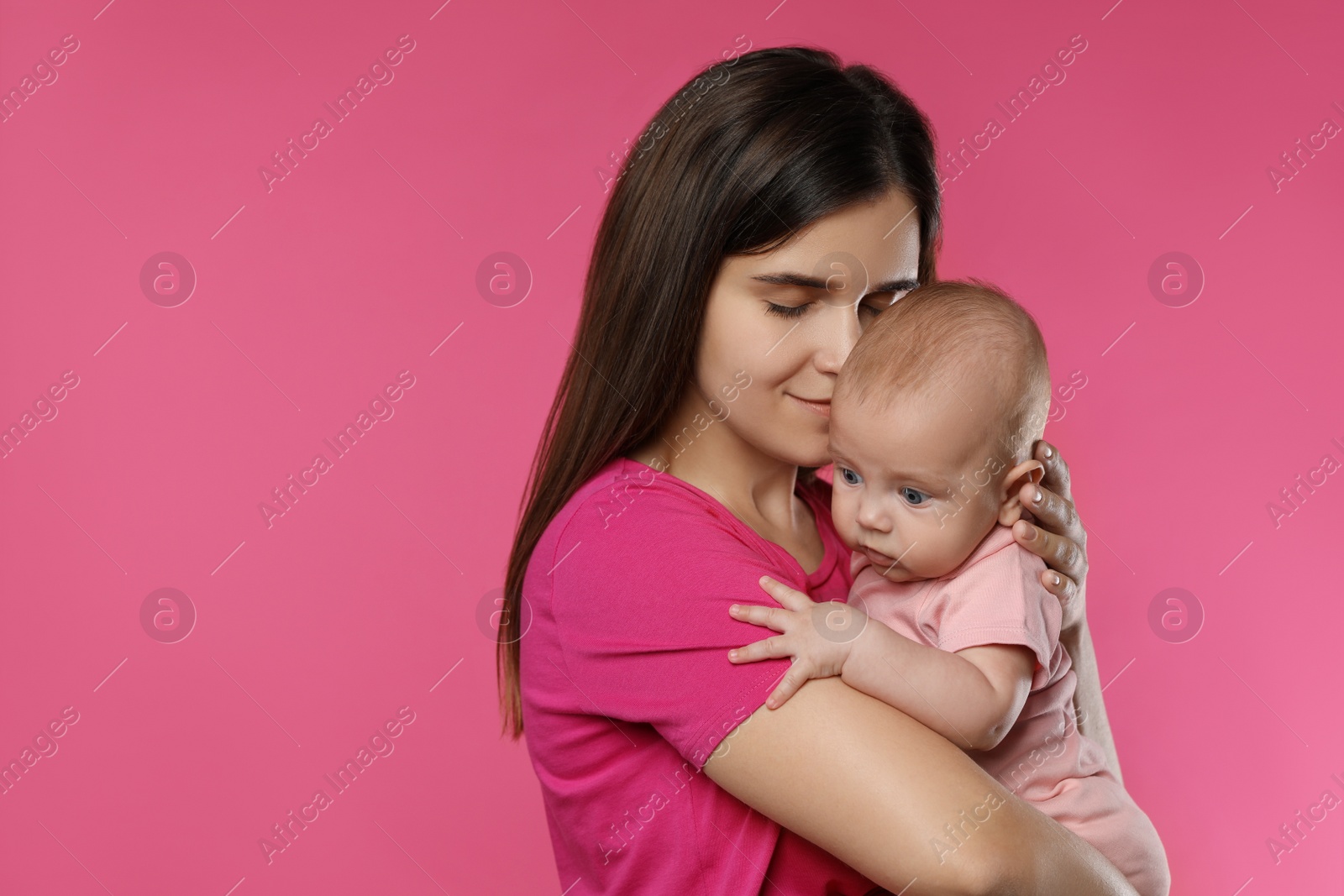 Photo of Beautiful mother with her cute baby on pink background. Space for text