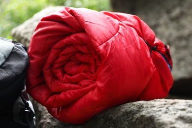 Rolled sleeping bag outdoors on sunny day, closeup