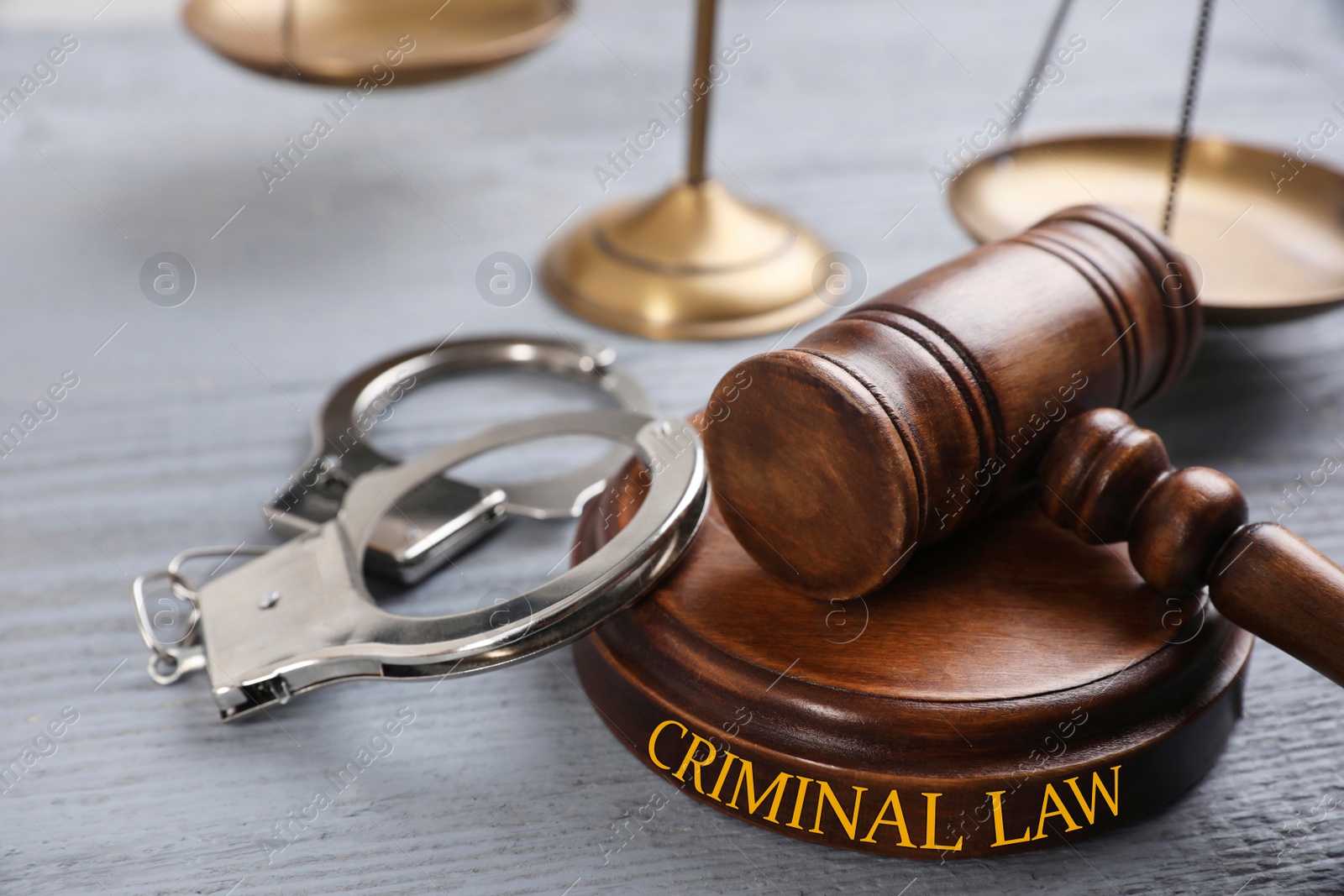 Image of Gavel, handcuffs and scales of justice on grey wooden table. Criminal law concept 