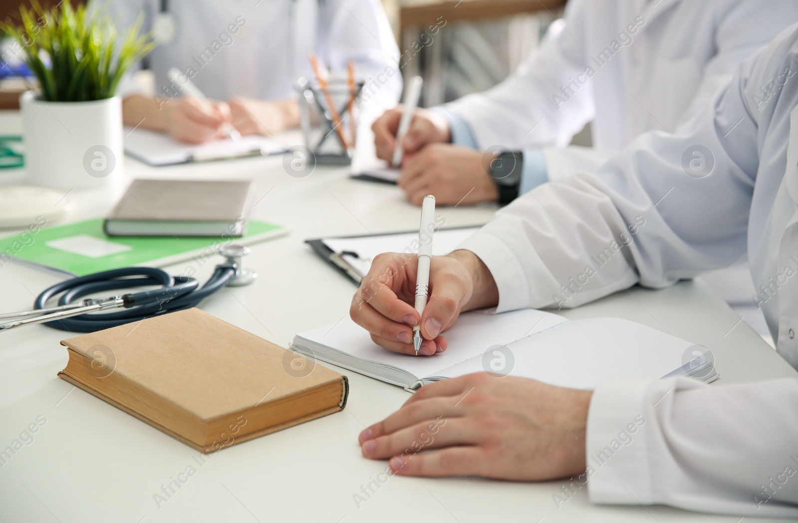 Photo of Doctors having meeting at table in office, closeup