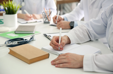 Doctors having meeting at table in office, closeup