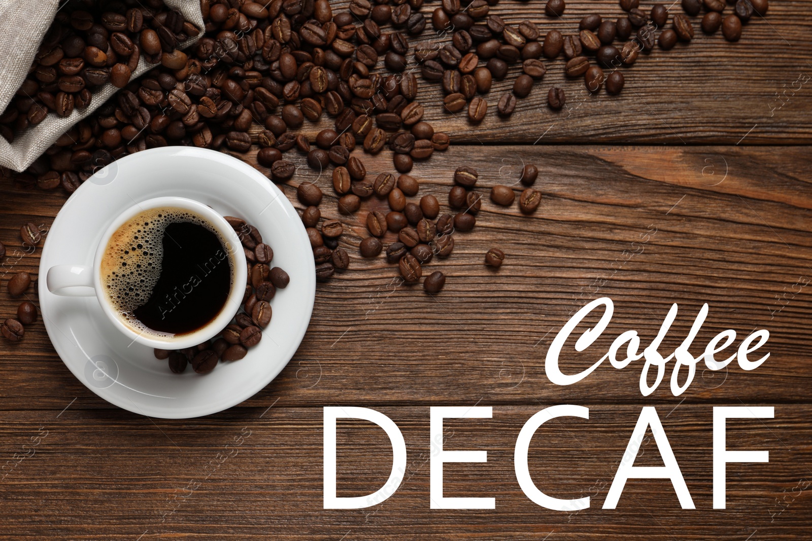Image of Cup of aromatic decaf coffee and beans on wooden table, flat lay