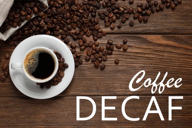 Image of Cup of aromatic decaf coffee and beans on wooden table, flat lay