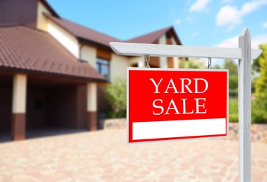 Image of Sign with text YARD SALE near modern house on sunny day