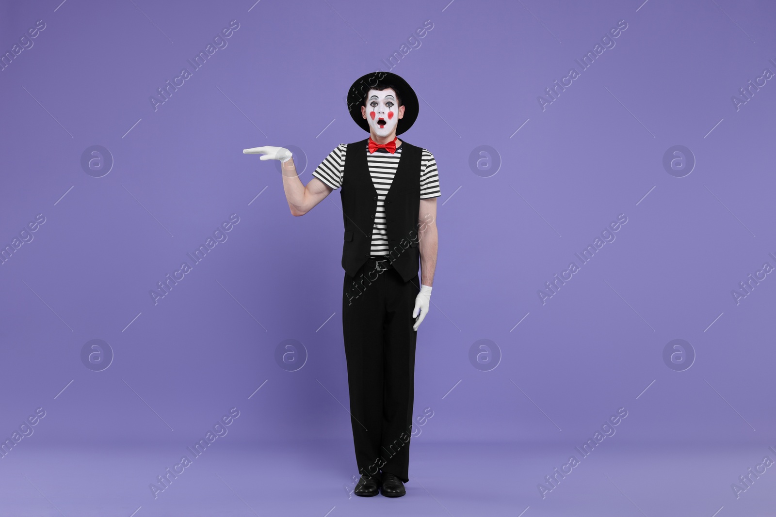 Photo of Mime artist making shocked face on purple background