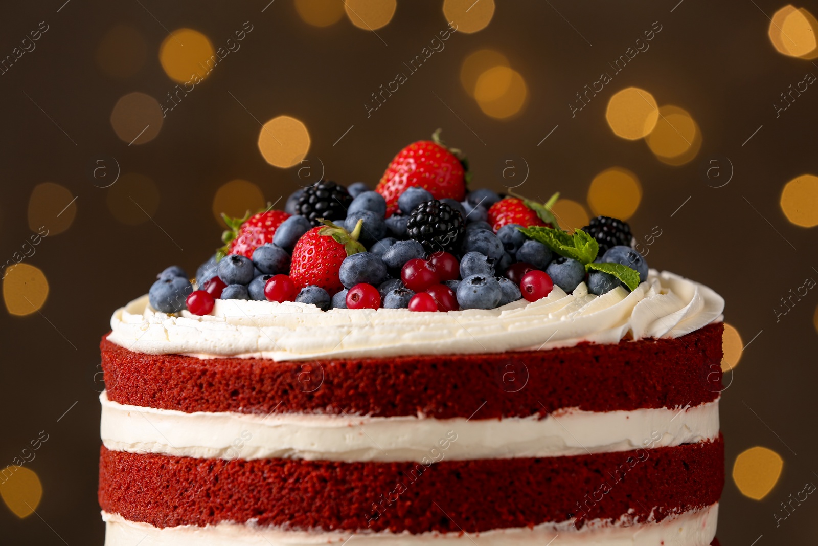 Photo of Delicious homemade red velvet cake against blurred lights