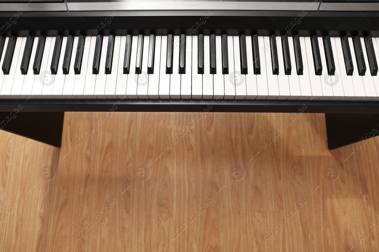 Photo of Modern piano with black and white keys over floor, top view. Space for text