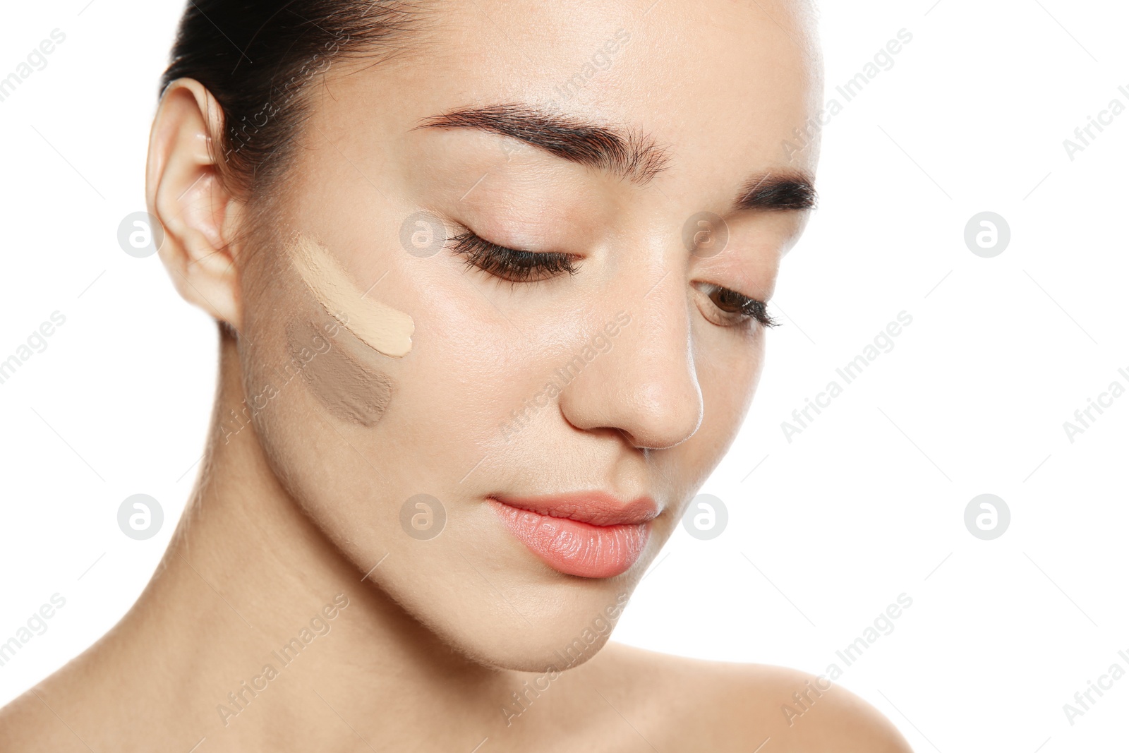 Photo of Young woman with different shades of skin foundation on her face against white background