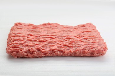 Photo of Raw fresh minced meat on white wooden table, closeup