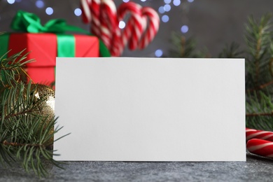 Photo of Blank greeting card near Christmas decorations on grey table, closeup. Space for text