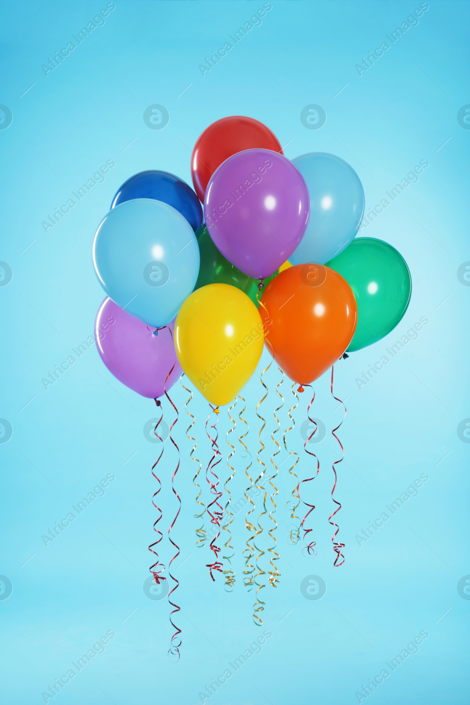 Photo of Many bright balloons floating on color background