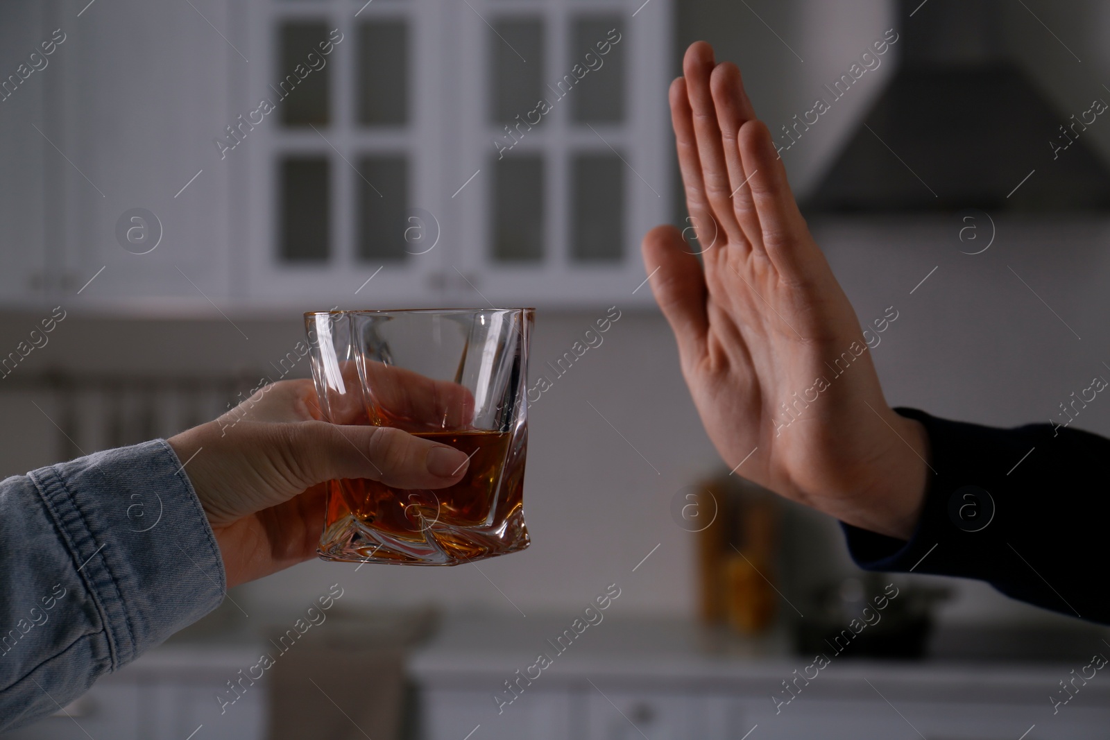 Photo of Man refusing to drink whiskey at home, closeup. Alcohol addiction treatment