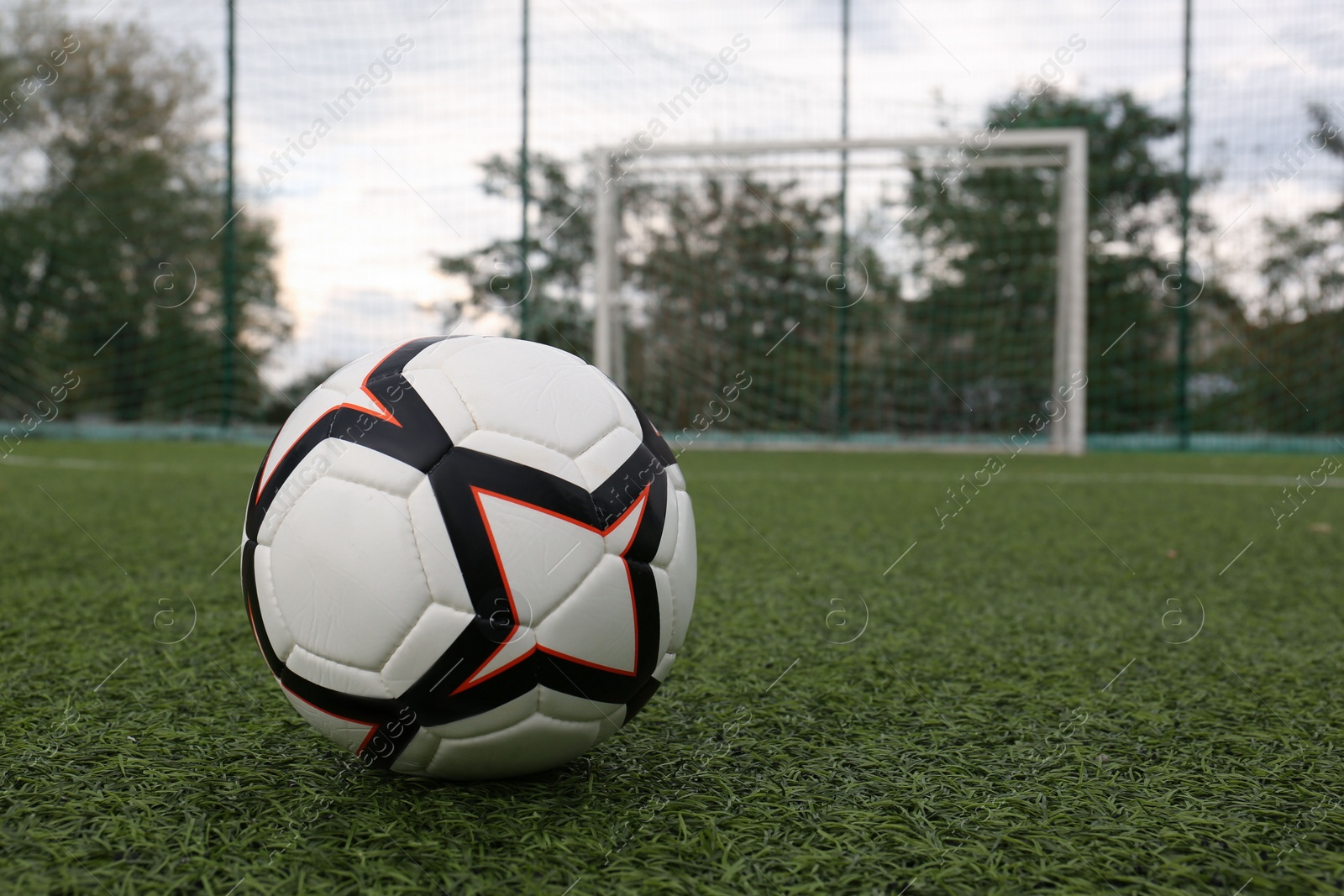 Photo of New soccer ball on green football field