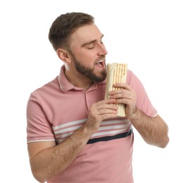 Young man eating delicious shawarma on white background