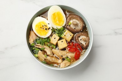 Bowl of delicious ramen on white marble table, top view. Noodle soup