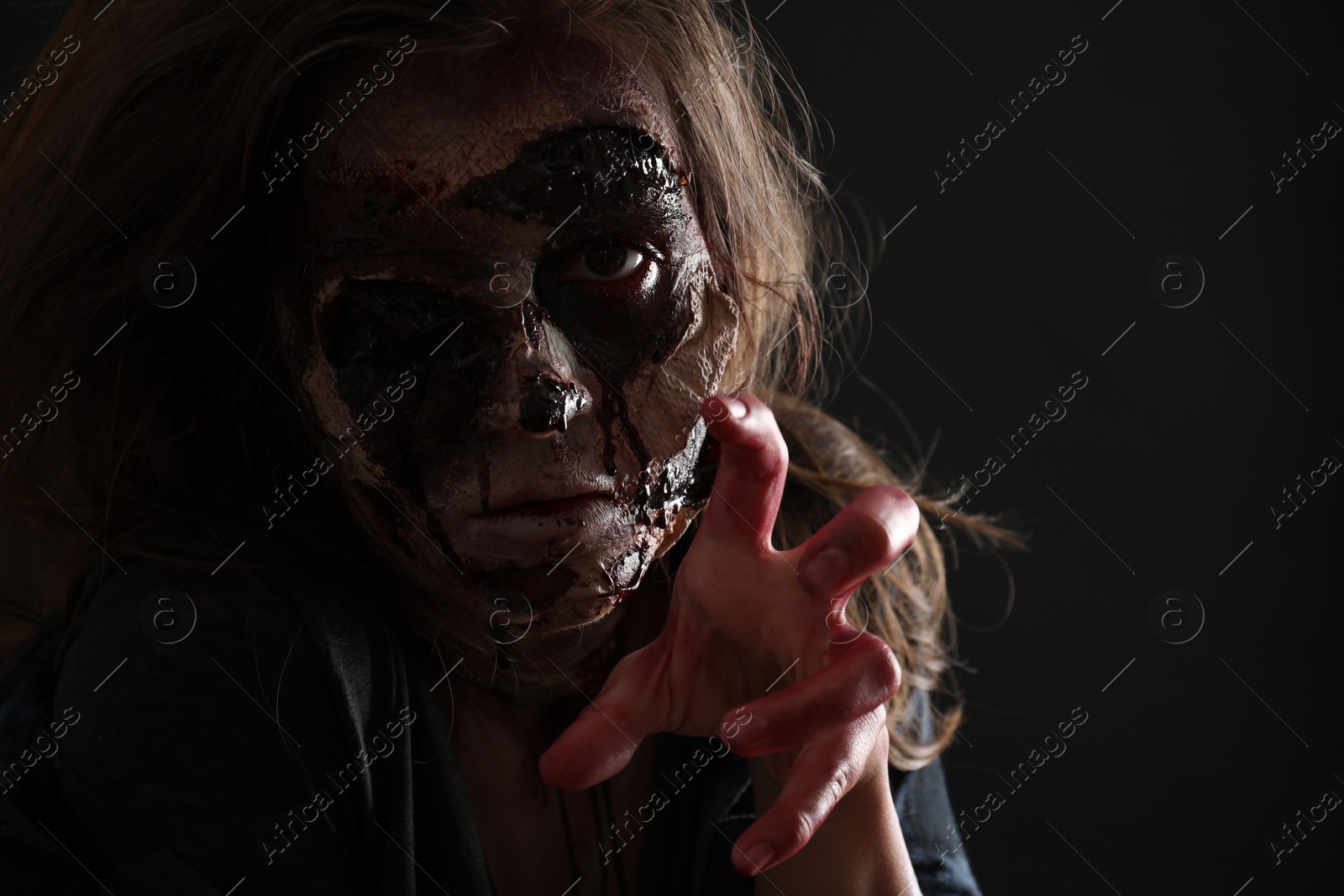 Photo of Scary zombie on dark background, closeup. Halloween monster