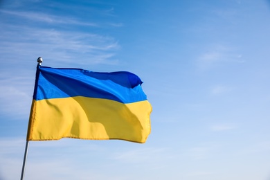 Photo of National flag of Ukraine against blue sky. Space for text