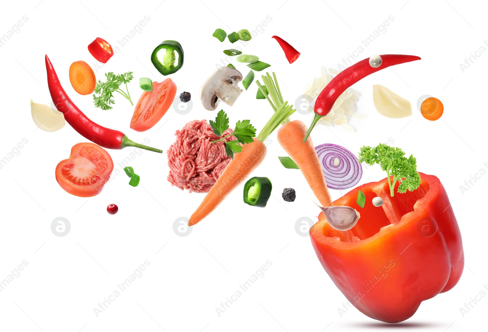 Image of Stuffed pepper recipe. Fresh ingredients falling into bell pepper on white background