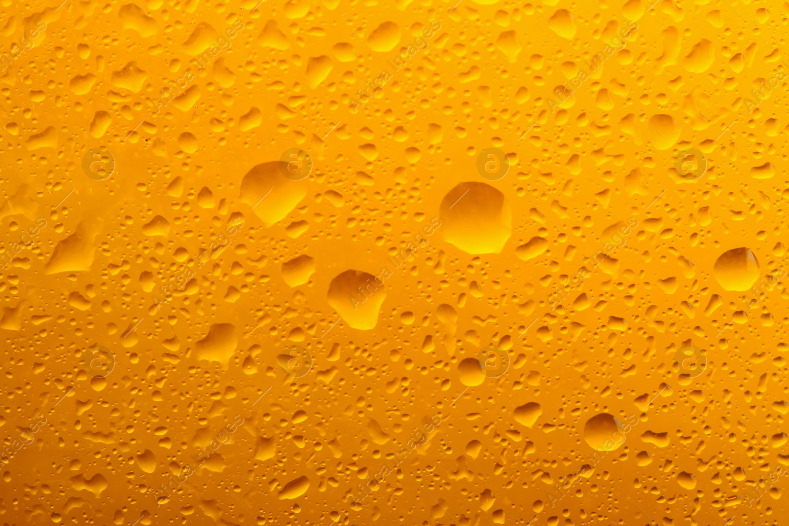 Photo of Glass of tasty cold beer with condensation drops as background, closeup