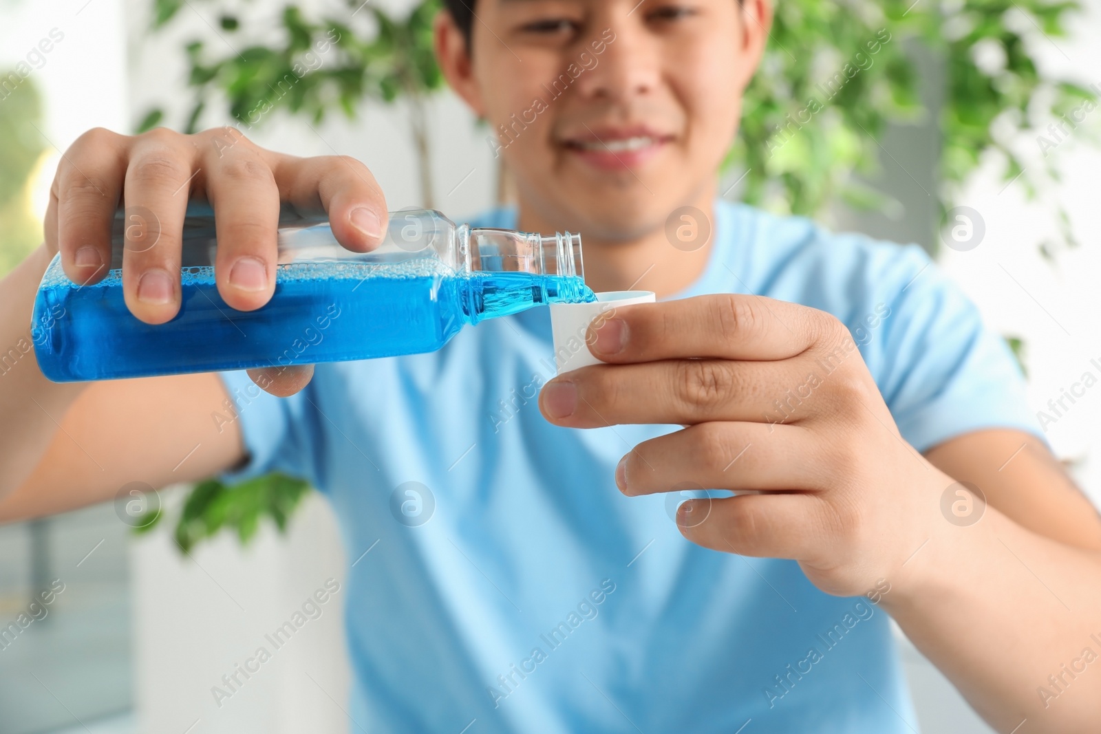 Photo of Man pouring mouthwash from bottle into cap, closeup. Teeth care