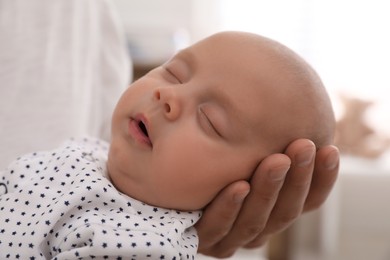 Photo of Father with her cute sleeping baby at home, closeup