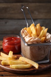 Photo of Tasty French fries served with ketchup on wooden table