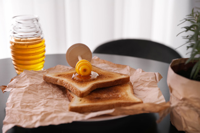 Photo of Delicious honey and toasts on black table