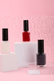 Photo of Stylish presentation of nail polishes on pink background