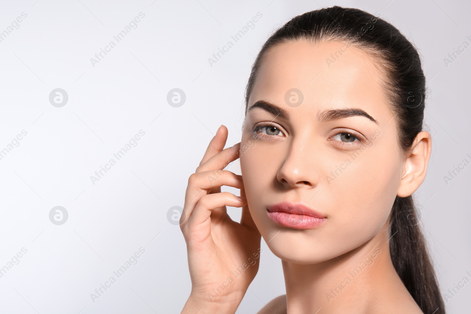 Photo of Beautiful woman with perfect eyebrows on light background