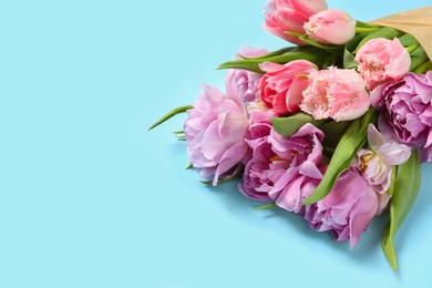Photo of Beautiful bouquet of colorful tulip flowers on light blue background, space for text