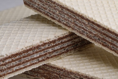 Delicious crispy wafers with chocolate filling as background, closeup view