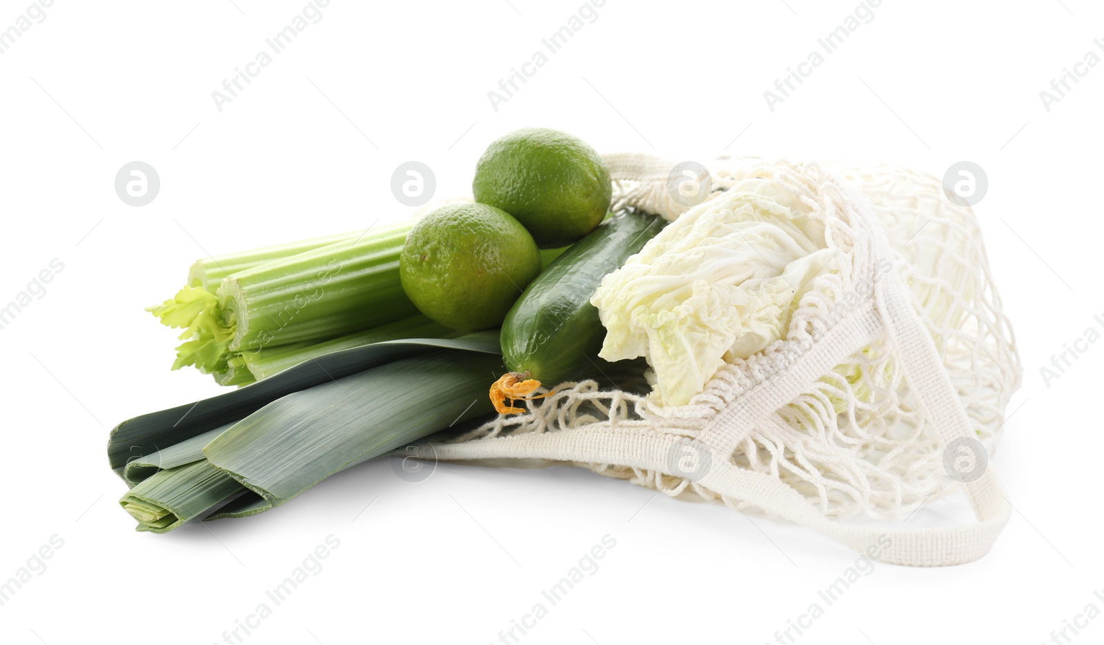 Photo of String bag with different vegetables isolated on white