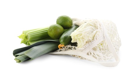 Photo of String bag with different vegetables isolated on white