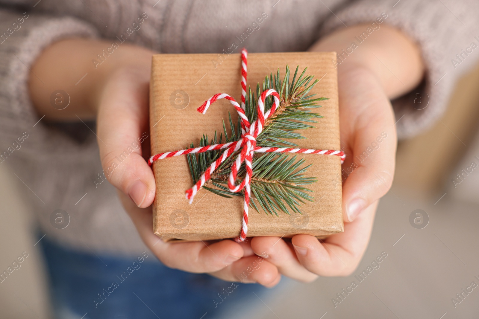Photo of Little child holding decorated box, closeup. Christmas gift