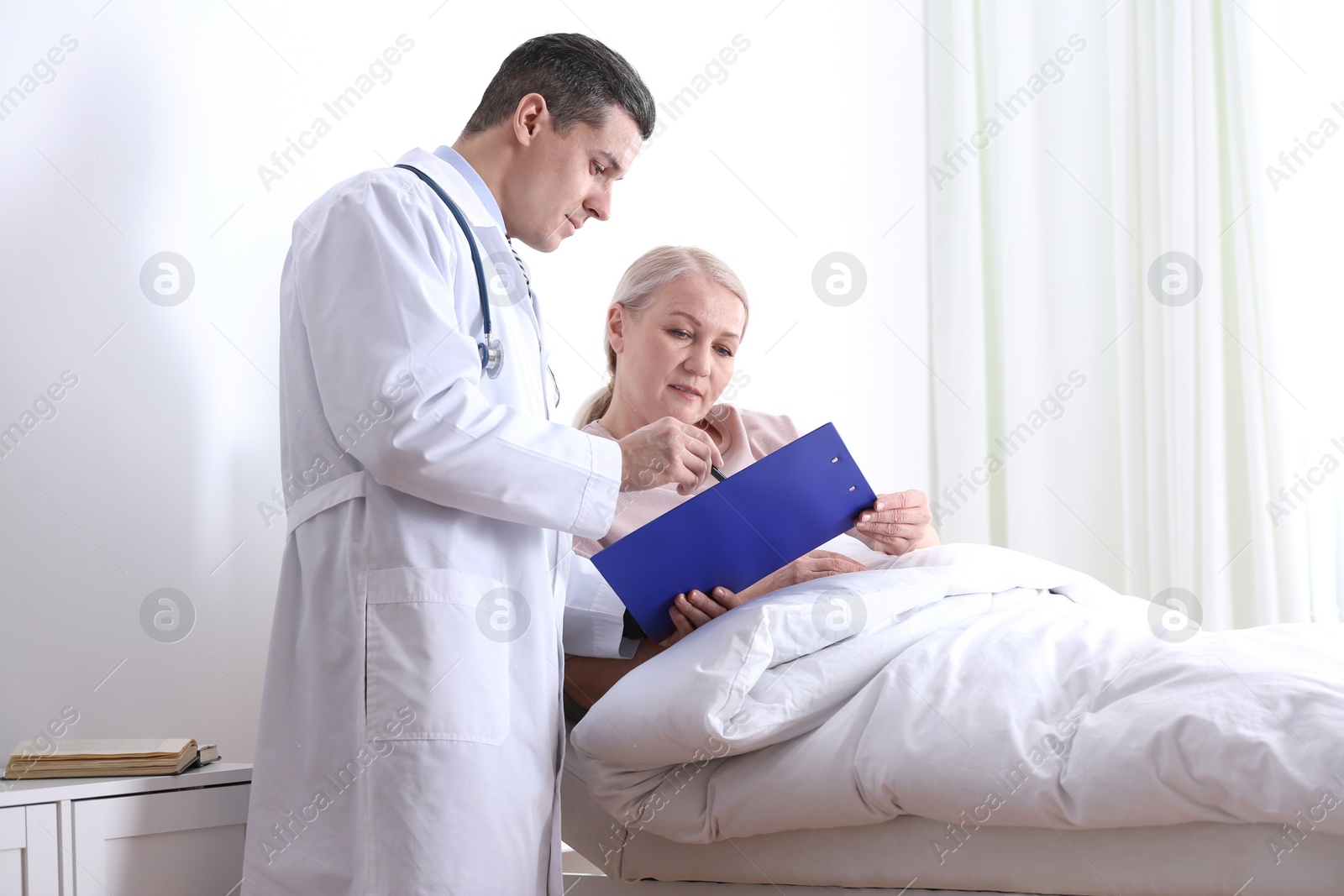 Photo of Doctor visiting his patient in hospital ward