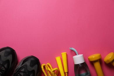 Sneakers, dumbbells and bottle of water on pink background, flat lay with space for text. Morning exercise