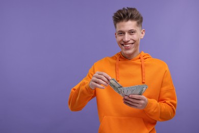 Photo of Happy man with money on purple background. Space for text