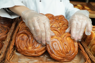Photo of Baker putting fresh bun onto tray, closeup