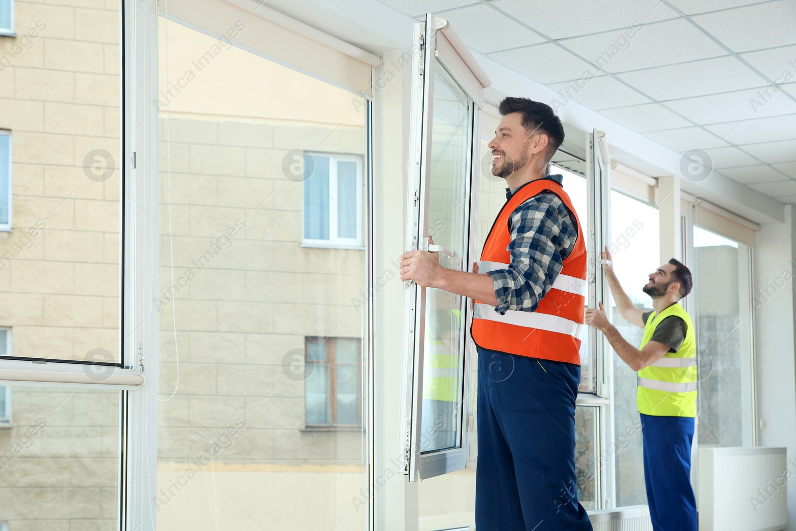 Photo of Construction workers installing plastic windows in house