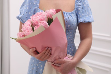 Woman with bouquet of beautiful fresh tulips on blurred background, closeup