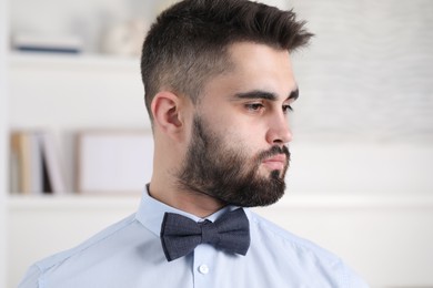 Photo of Portrait of handsome man in shirt and bow tie indoors