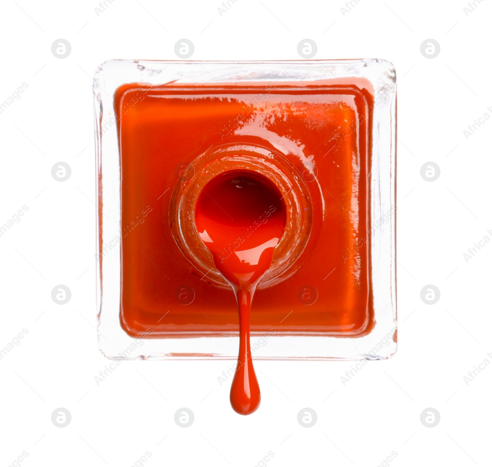 Photo of Orange nail polish dripping from bottle isolated on white