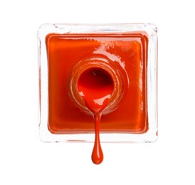 Orange nail polish dripping from bottle isolated on white