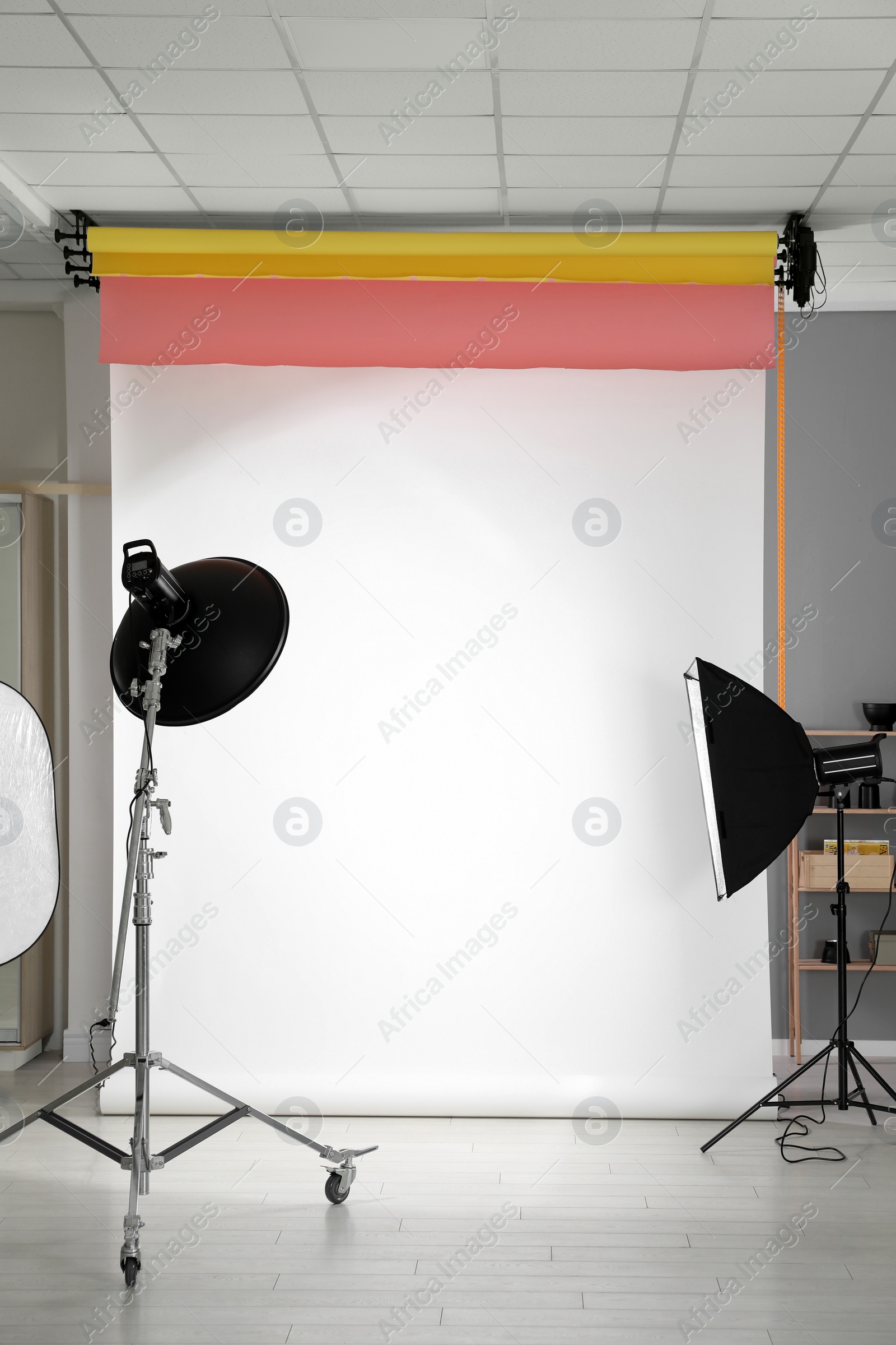 Photo of White photo background and professional lighting equipment in modern studio