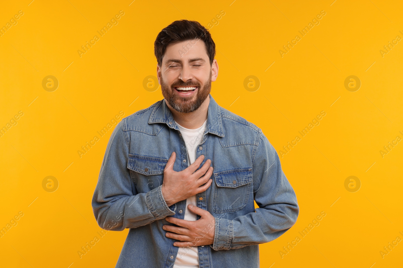 Photo of Portrait of handsome man laughing on yellow background