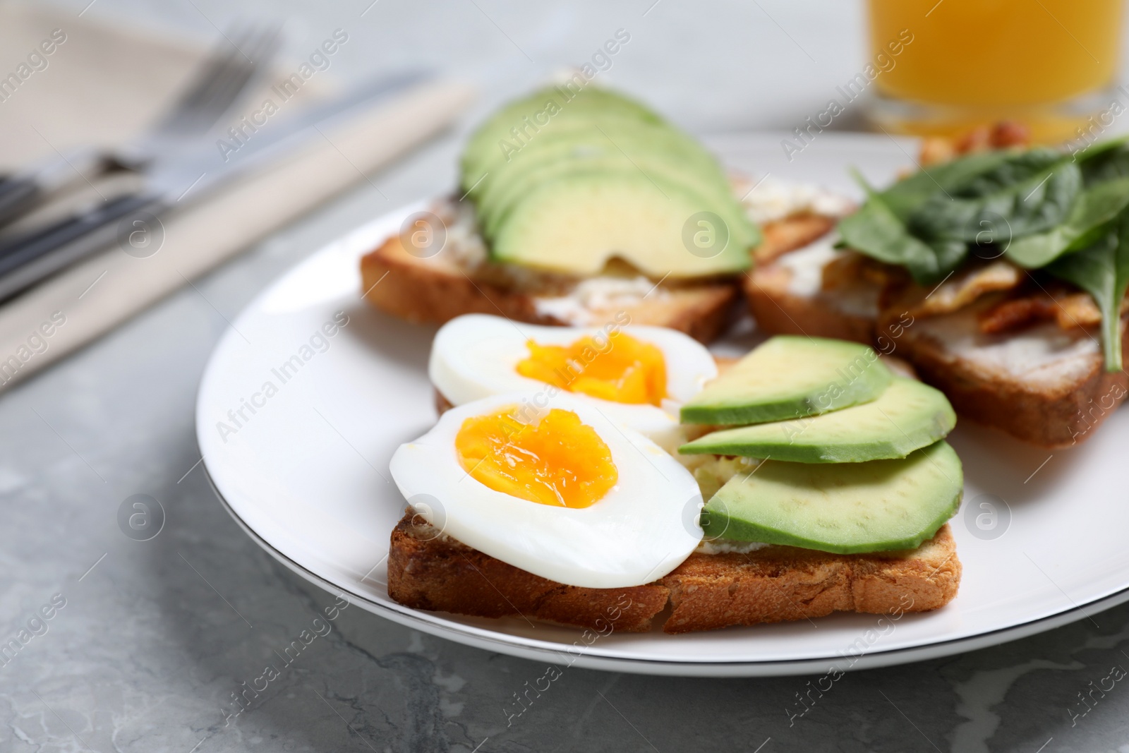 Photo of Delicious sandwiches served for breakfast on grey table, closeup