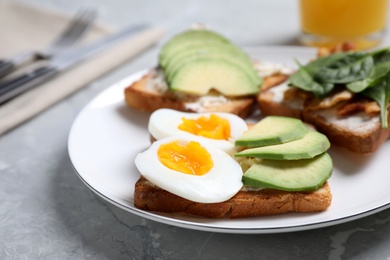 Delicious sandwiches served for breakfast on grey table, closeup