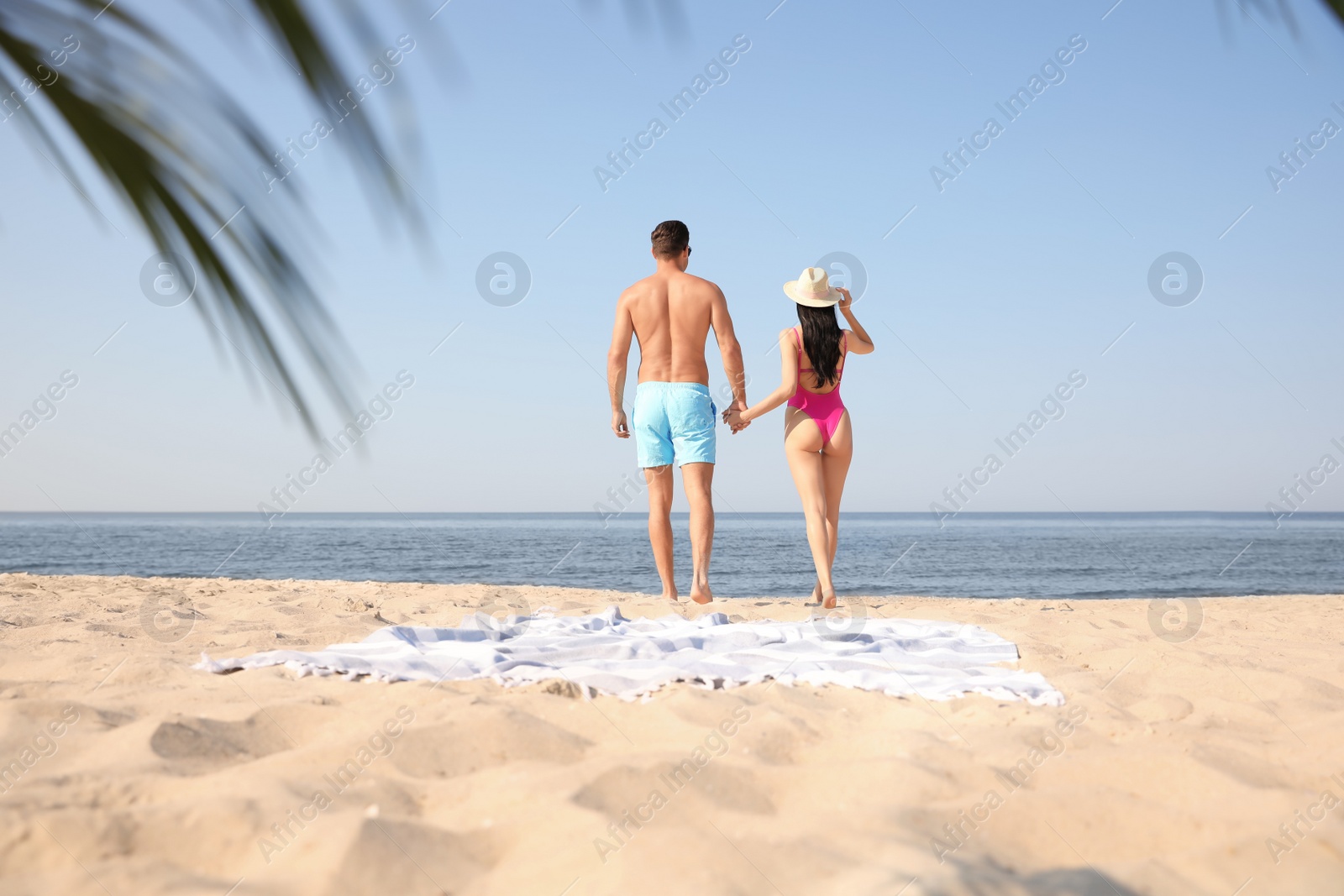 Photo of Couple resting on sunny beach at resort